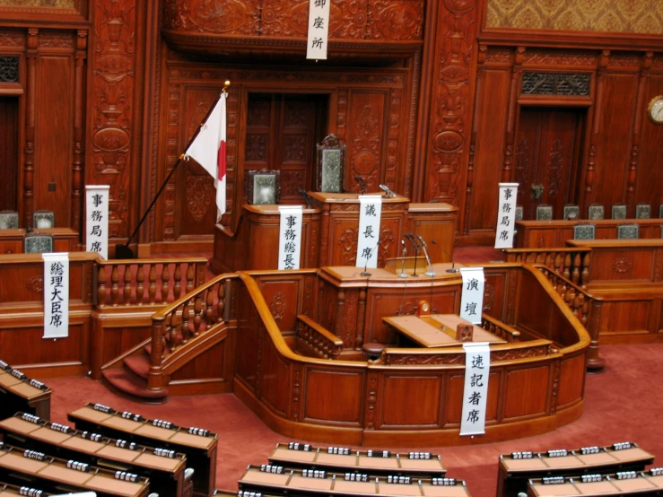 the interior of an empty, large courtroom with signs all around it