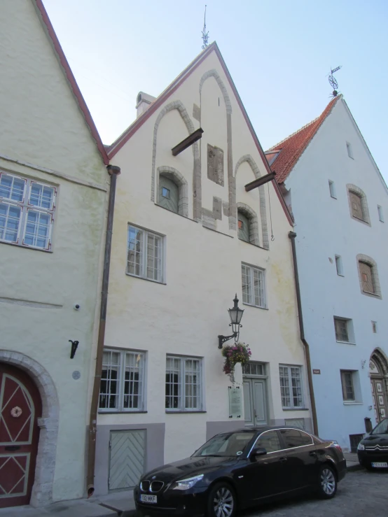 two parked cars sitting in front of a tall building