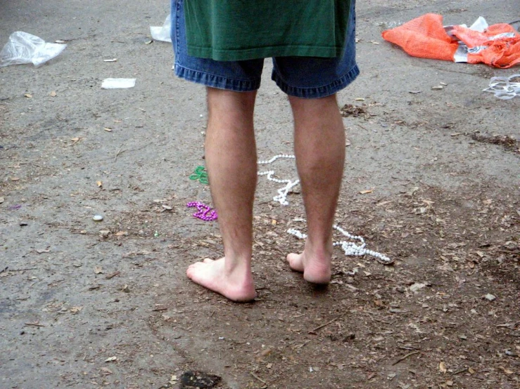 a man's bare feet with a bunch of garbage