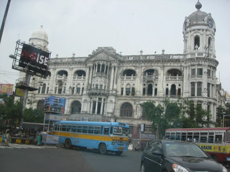 a large white building with cars on the street