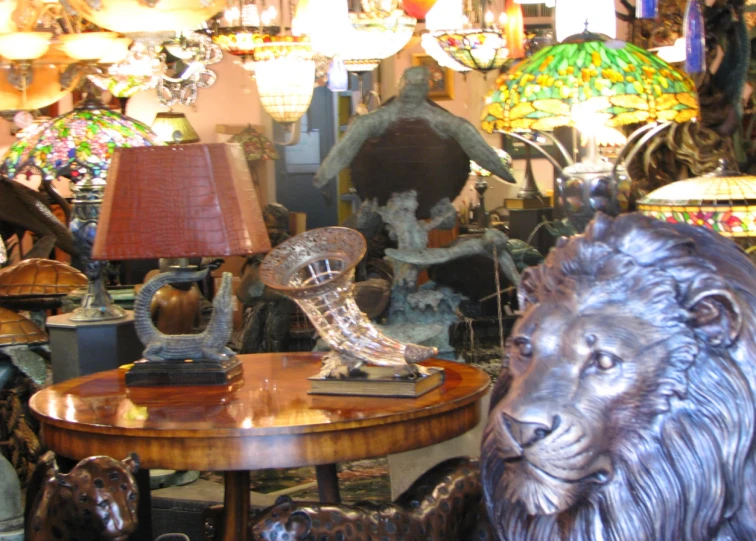 a statue sitting on a table next to a chair and lamp