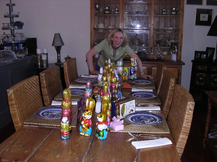 a lady is standing behind a long table full of colorful objects