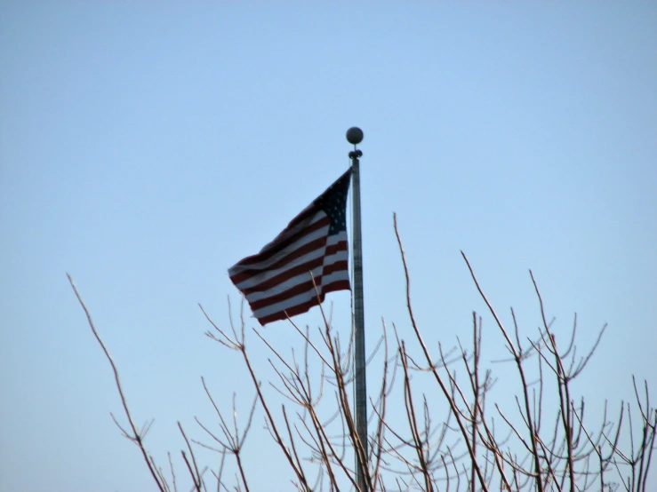 a very large american flag is flying high in the air