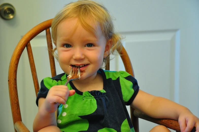 a  is sitting in a chair with food in her mouth