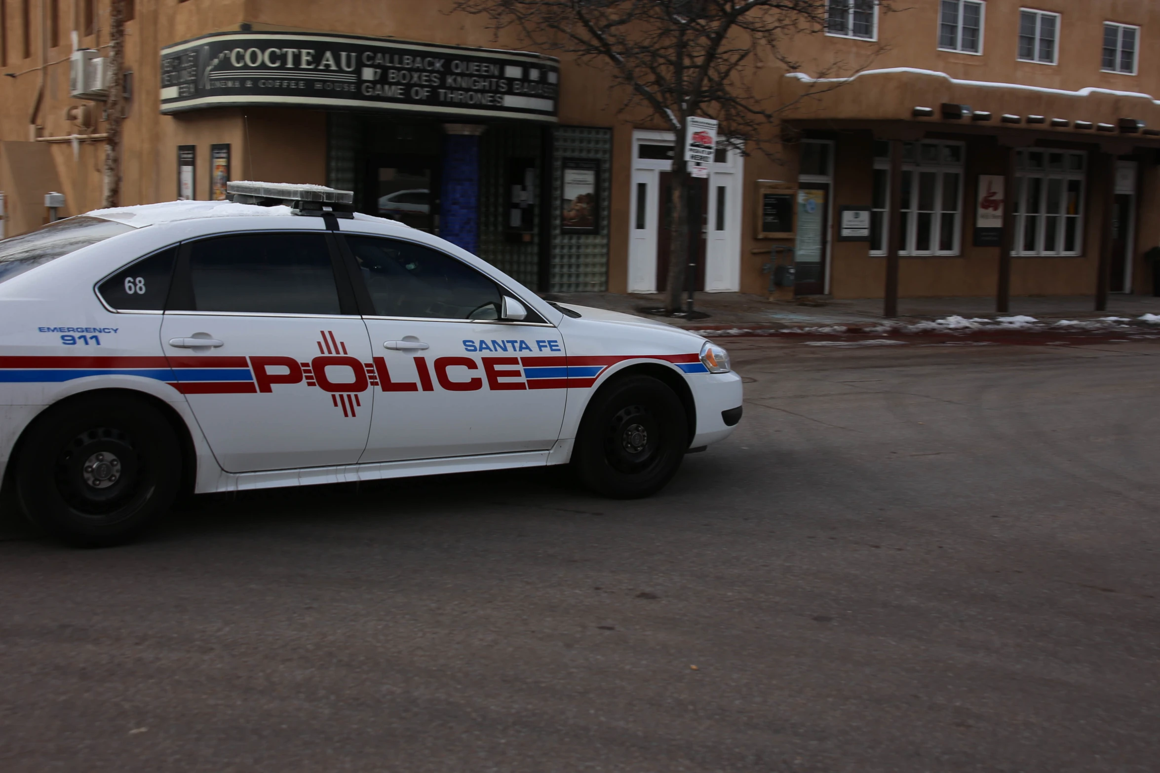 a police car parked on the street near some buildings