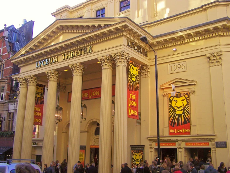 an old building with columns and flags at the entrance