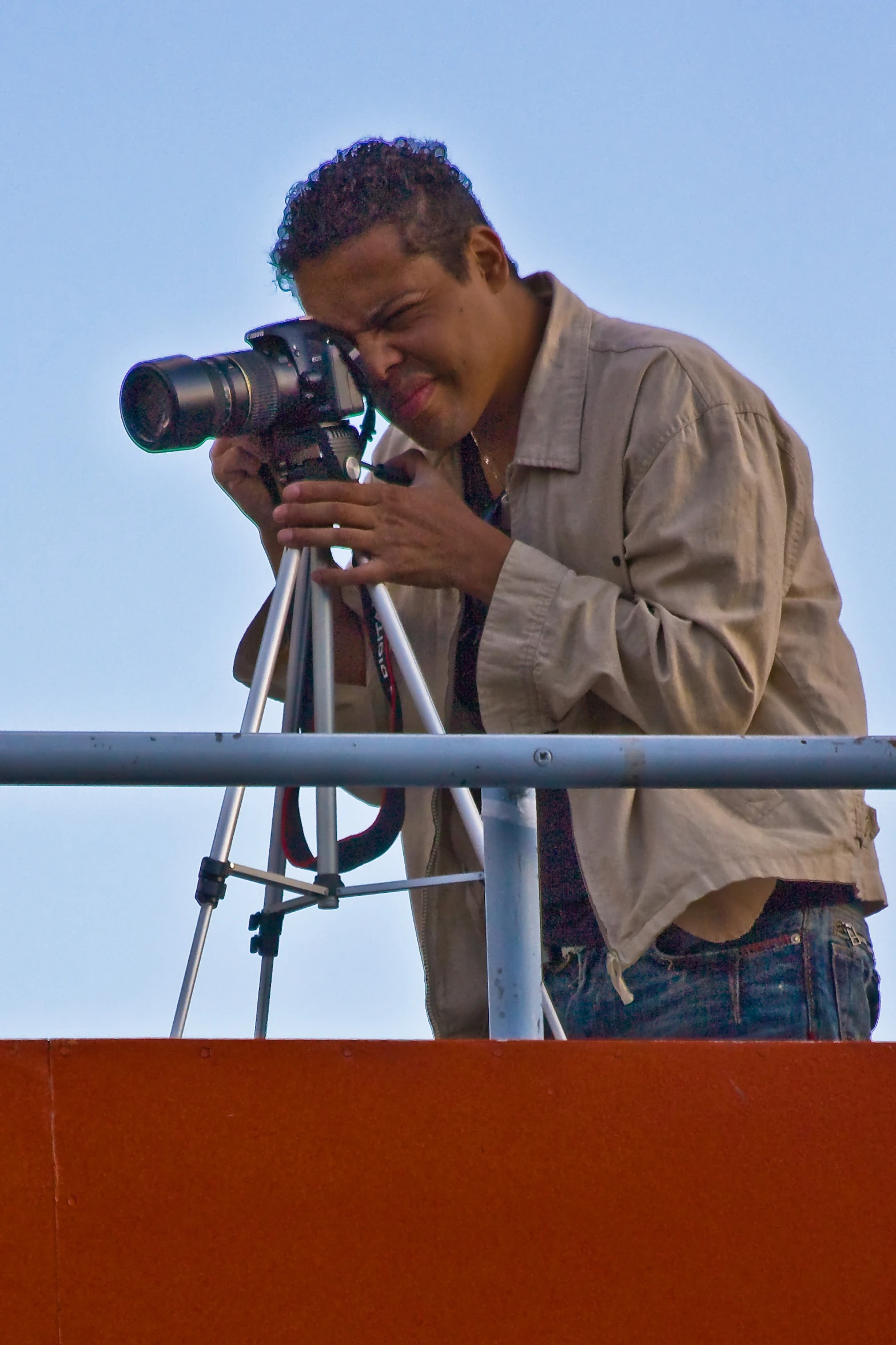 a man holding a camera on top of a roof