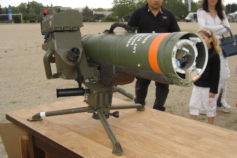 a couple people stand behind a large, military cannon