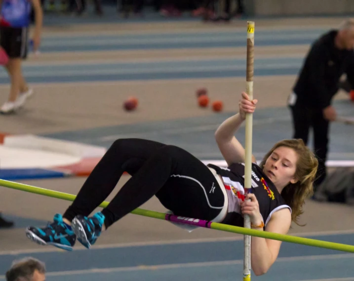 a woman leaning up against a pole with a pair of legs and feet