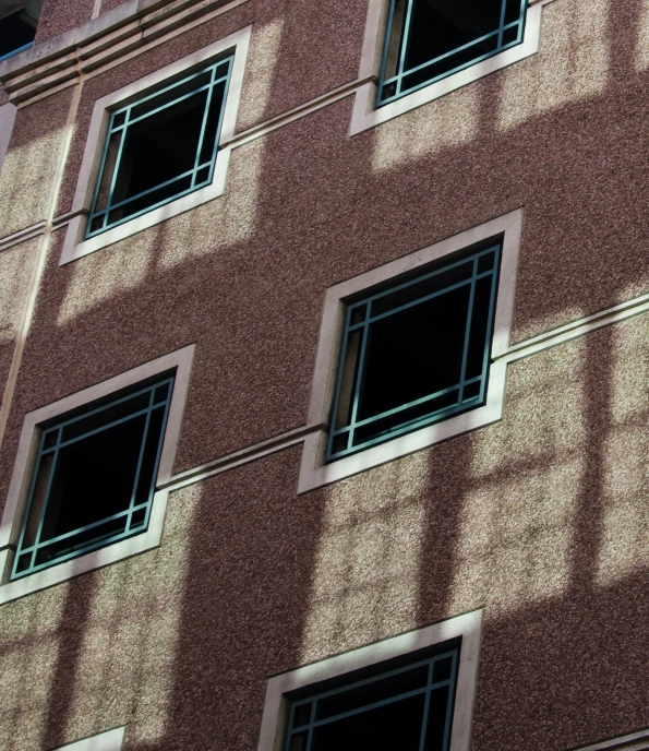 an orange building with windows and a clock mounted to it's side