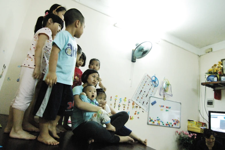 several s are standing around a room while one holds a baby