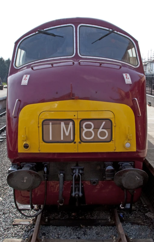 the side of a train car that has been painted maroon and yellow