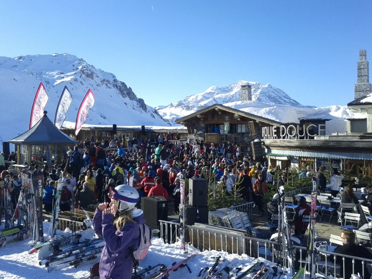 several skiers on snow covered ground and people on the building