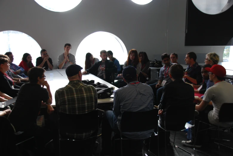 people are sitting at a table with round windows in the background