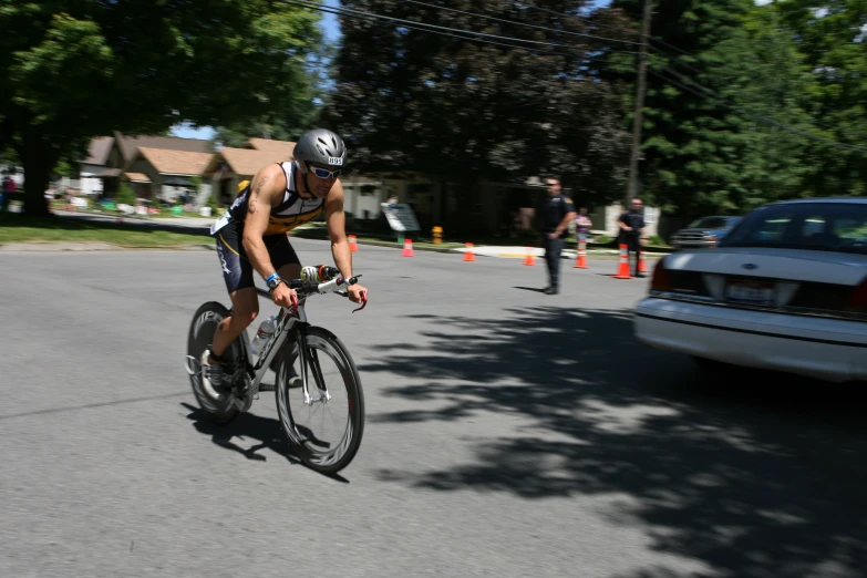 a young man riding a bicycle while holding onto his helmet