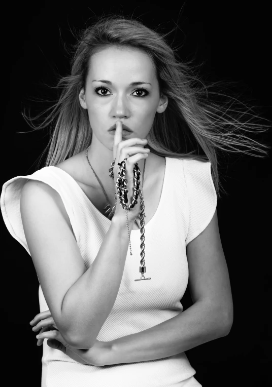 a beautiful young woman posing with her hands on her lip