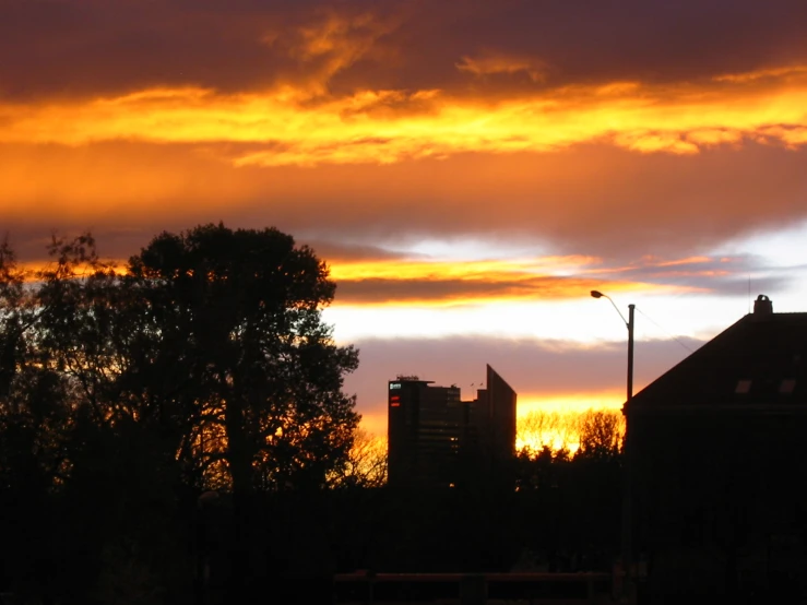 a large orange and pink sky with some buildings