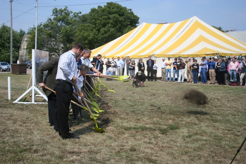 two men are placing grass on top of a potted animal