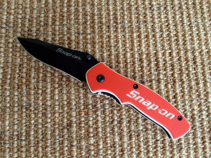 a red and black swiss army knife on a table