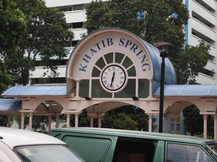 a parking lot with an awning and large clock at the top