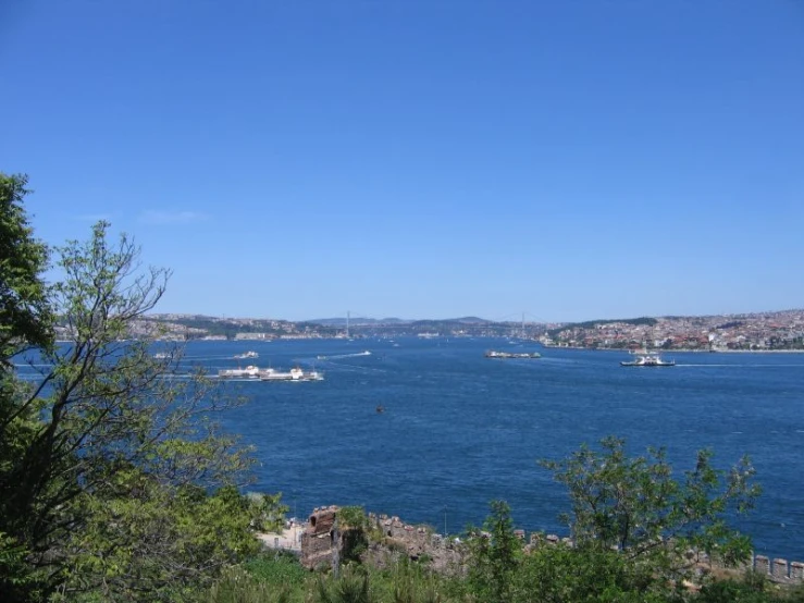 large blue ocean with small ships in the distance