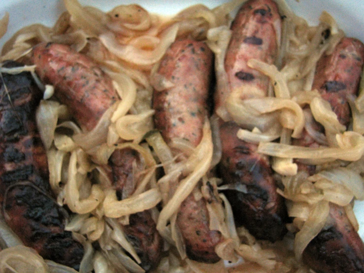 a bunch of sausages and onions in a bowl