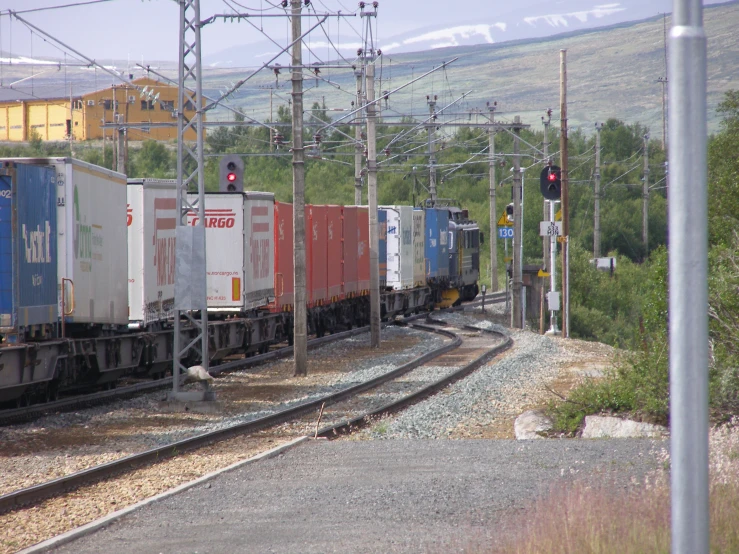 a train drives down some tracks with many cars