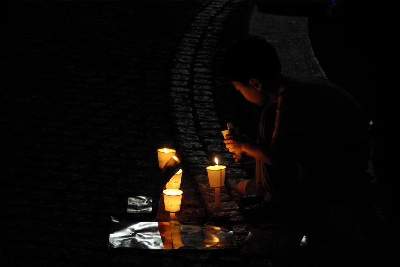 a person standing over a table with candles