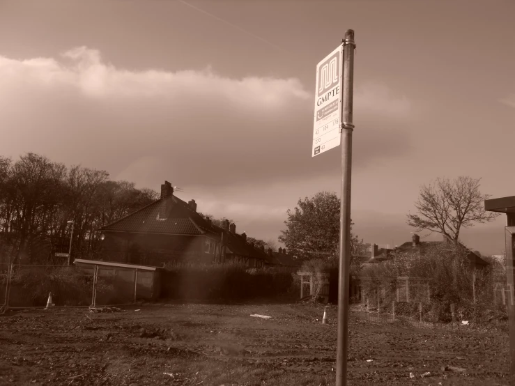 this black and white pograph shows a signpost near a road