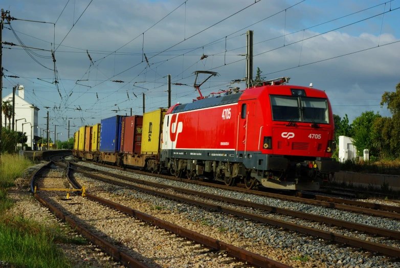 the large red train is pulling its cars down the tracks