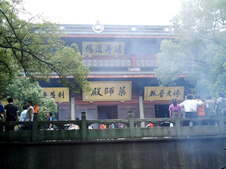 people are standing outside a chinese building and some have signs