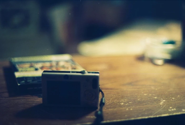 a camera, cellphone and a glass on a table