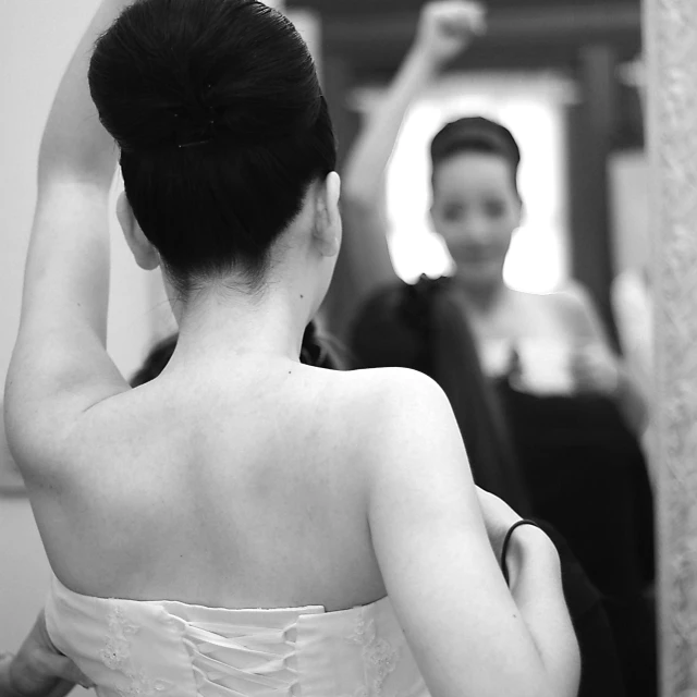 the back of a bride's dress as she stands by another woman