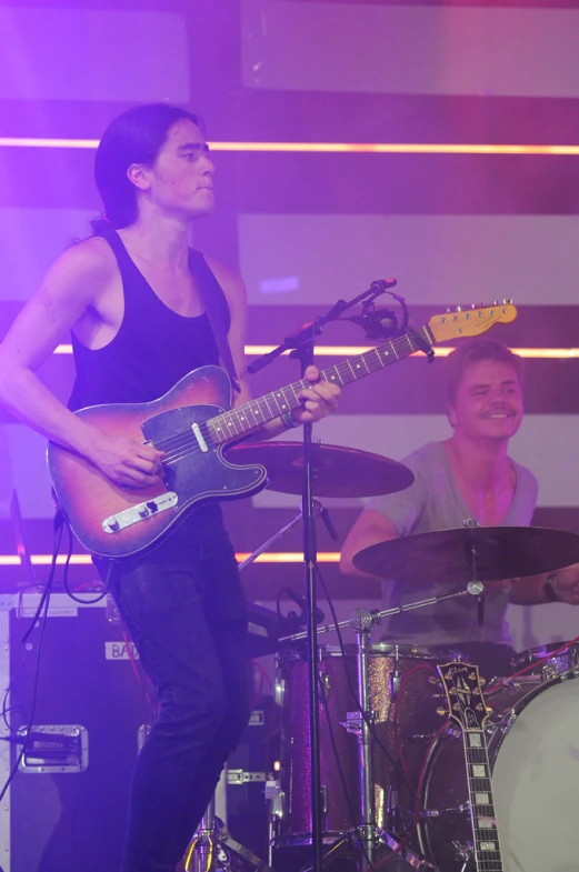 a young woman on stage with her guitar