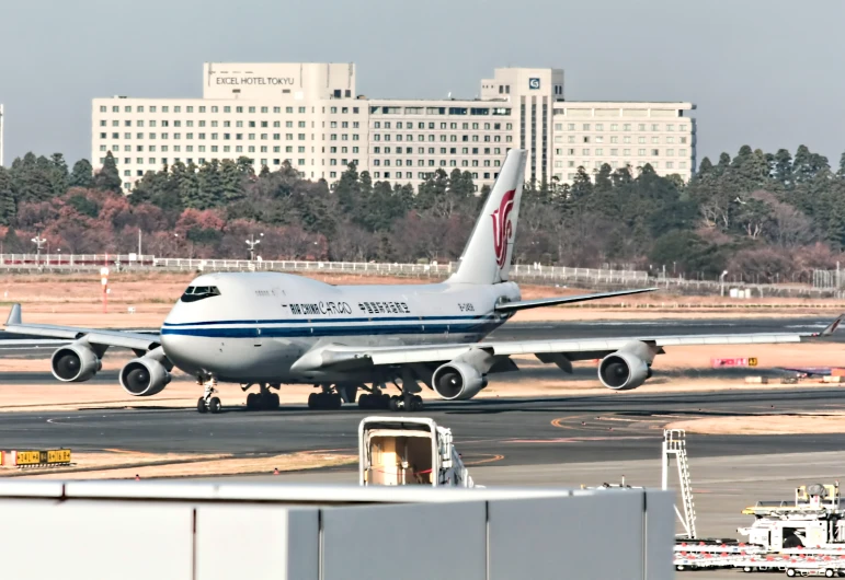 an airliner is on the tarmac with other aircraft in the distance