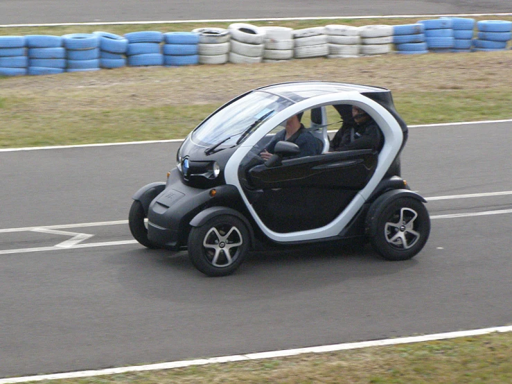 a black and white car driving down a race track