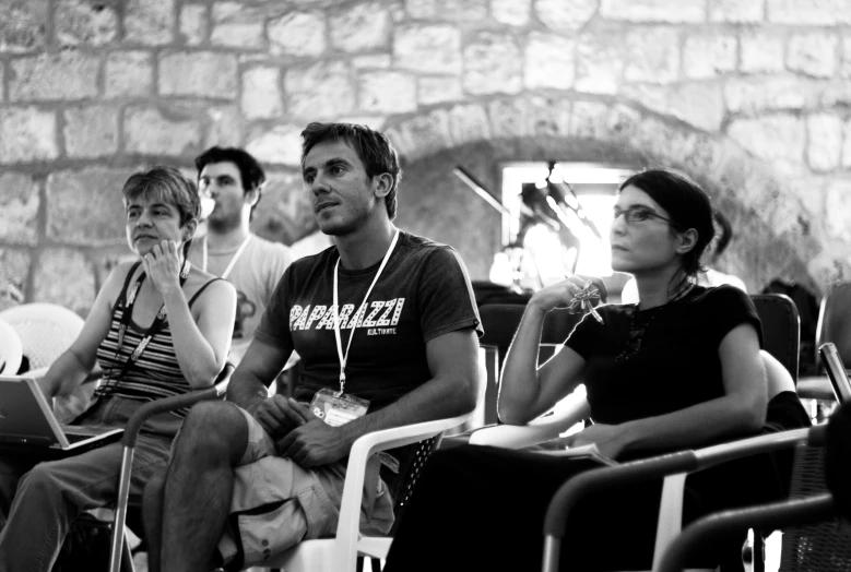 a black and white po of several people sitting in chairs watching soing