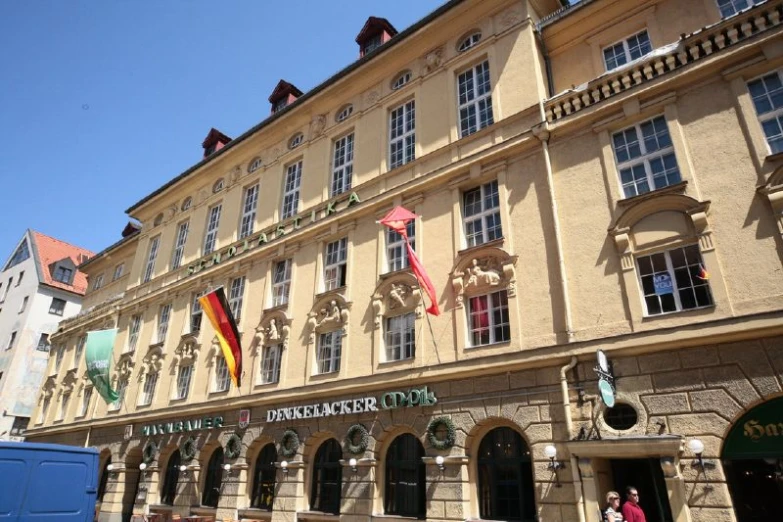 some people are walking in front of a large building