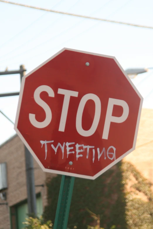 stop sign with graffiti written underneath it on the street