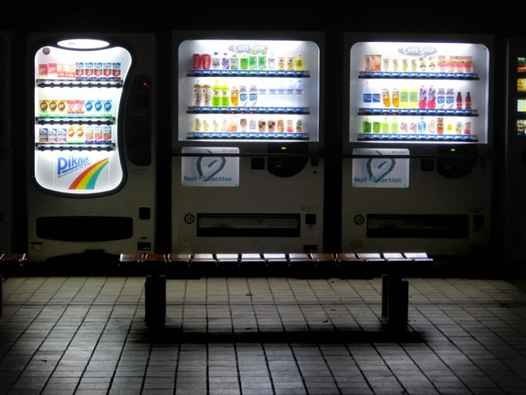 a row of vending machines sitting next to each other on a tiled floor