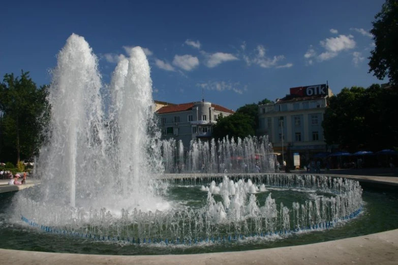 there is a large fountain in front of some buildings