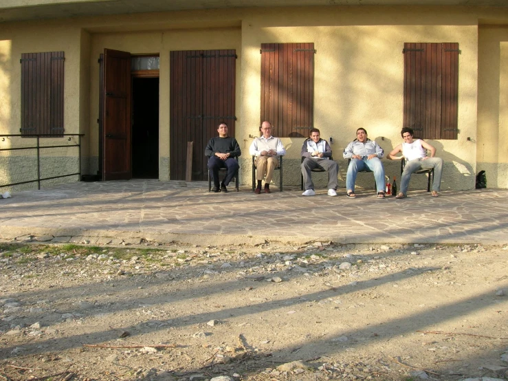 men sitting on the outside of an old building