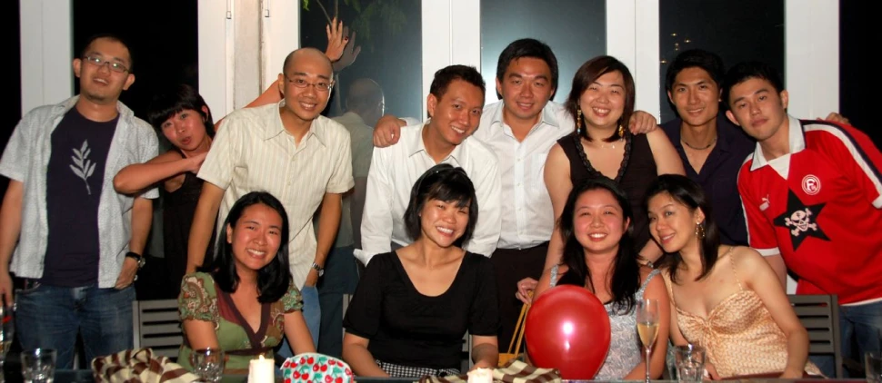 a group of people stand and pose for a po in front of balloons