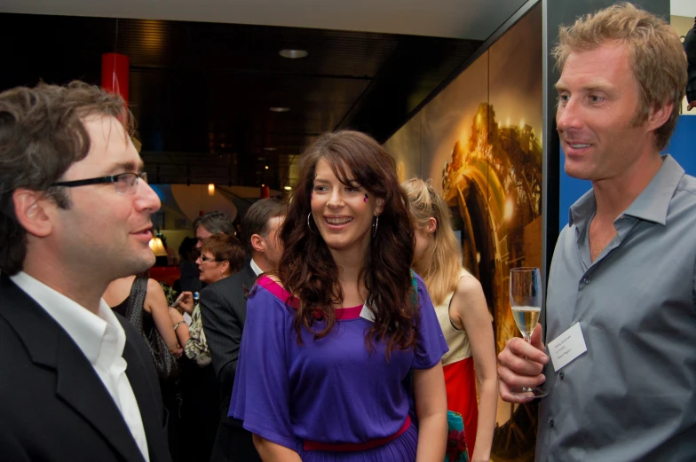 two men and a woman stand talking to each other