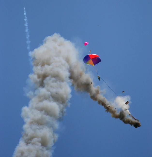 smoke pouring out of the side of a red blue and green kite