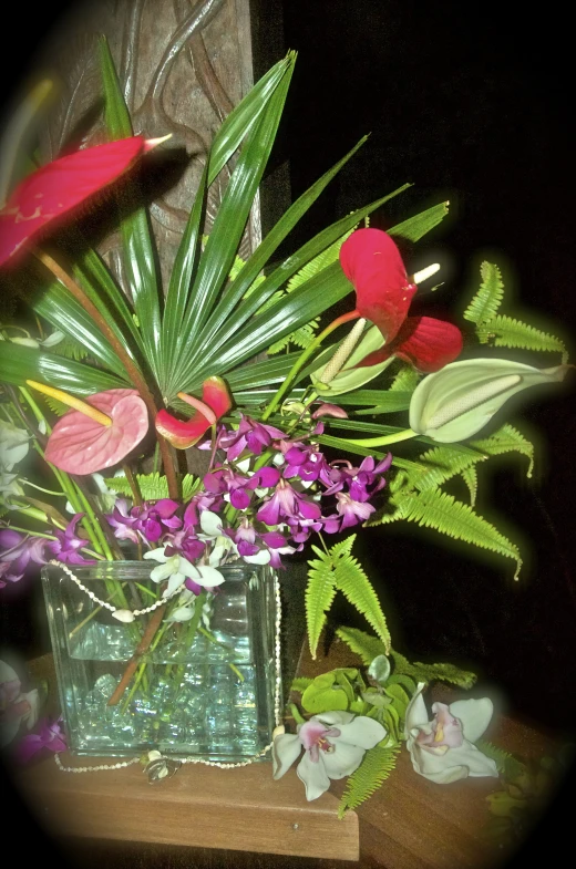 a vase filled with flowers and palm leaves