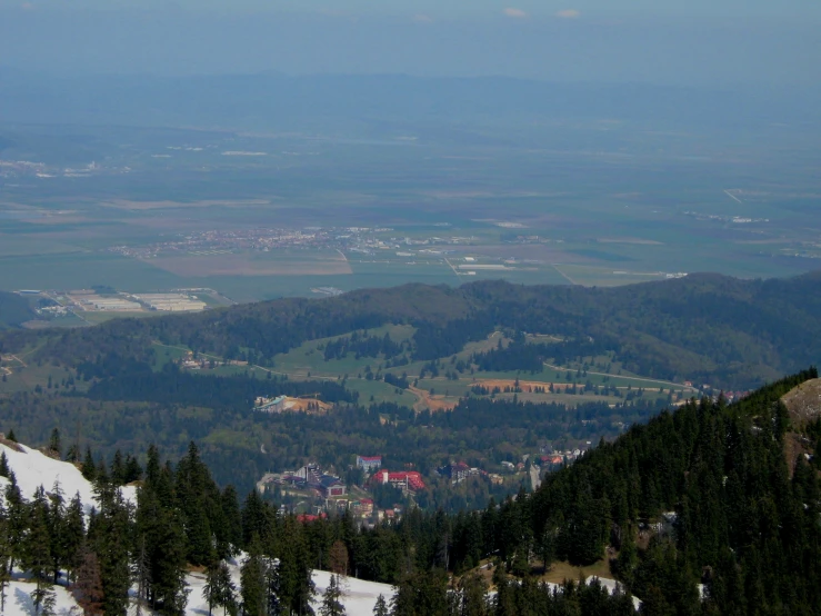 the view from a high vantage point on a mountain shows a green valley and trees