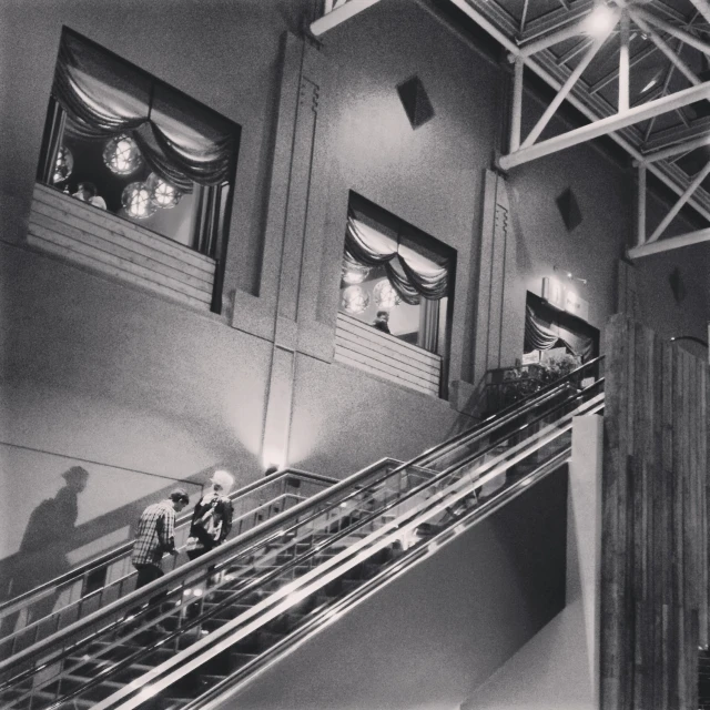 the lobby of an old building with people on escalators