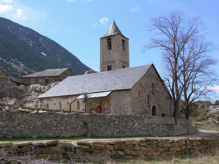 this church in the mountains is surrounded by stone walls and an old - fashioned bell tower