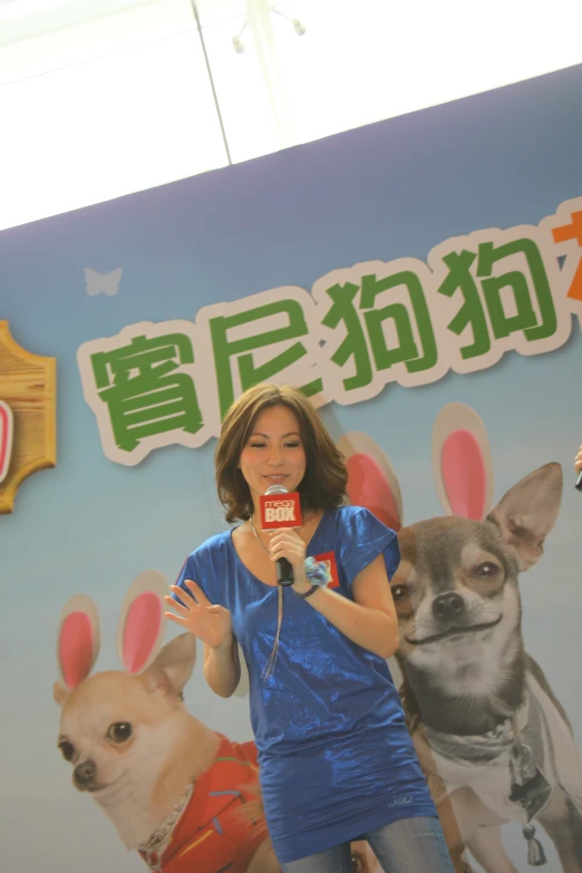 a woman is performing on a stage while three dogs stand in the background